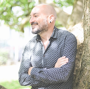 Photo en couleur de David GIRON adossé à un arbre